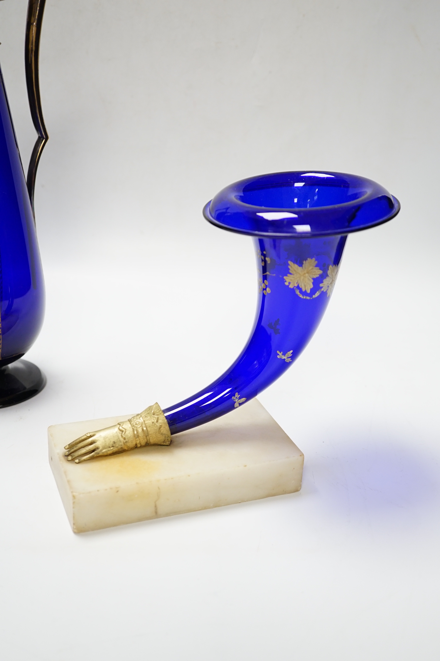 A 19th century Bristol blue cornucopia trumpet with metal hand mount with gilt decoration and a gilt decorated and mounted Bristol blue claret jug, jug 31.5cm high